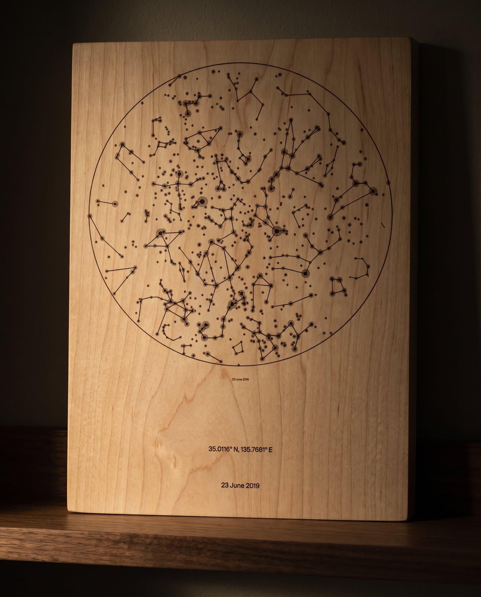 A star chart printed onto a pale maple panel, the grain running through it